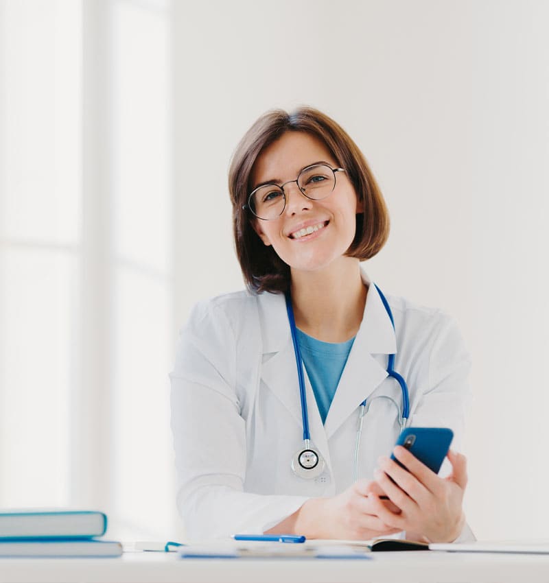 Contabilidade para área da saúde - imagem de médica sorrindo com o smartphone na mão